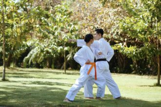 Atlet de taekwondo cu centură neagră care îi predă prietenei tehnici de apărare