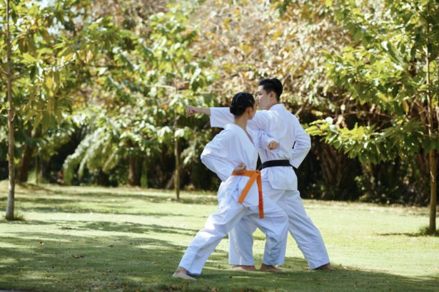 Atlet de taekwondo cu centură neagră care îi predă prietenei tehnici de apărare