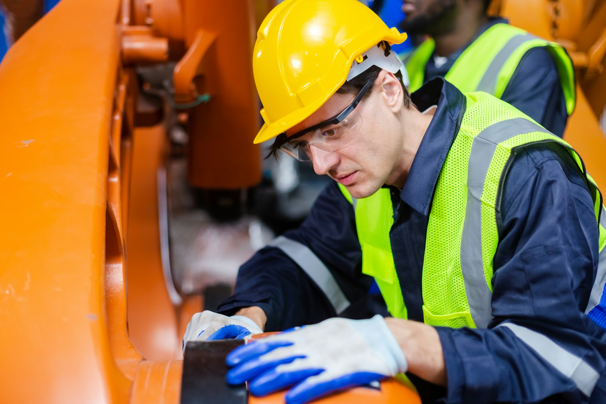 Inginer tehnician masculin care verifică brațul robotic de automatizare la o fabrică industrială modernă.