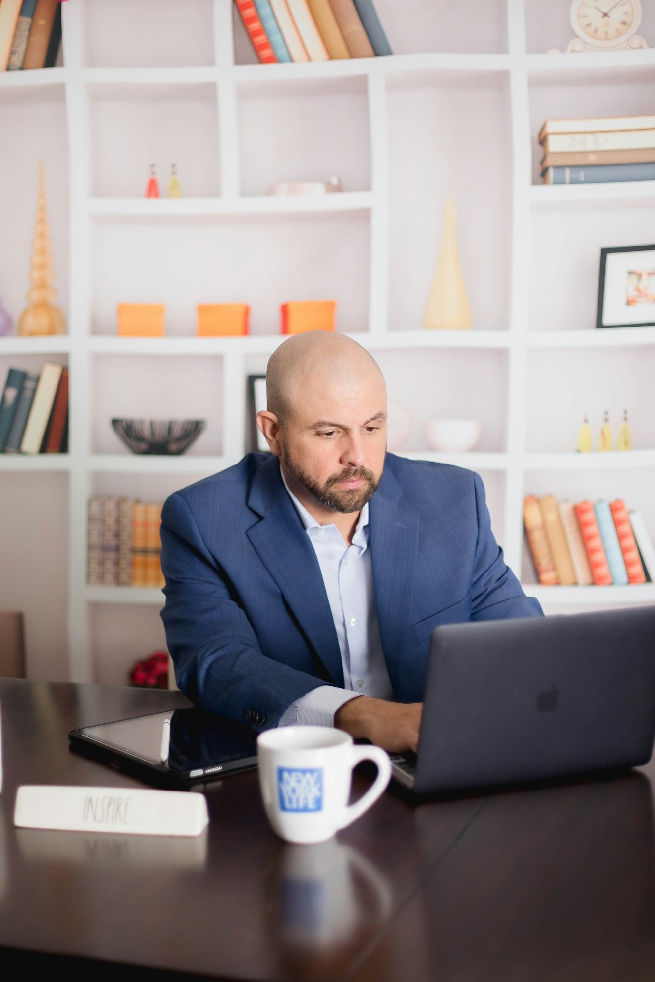 Un om de afaceri chel în ținută formală, lucrând la laptop