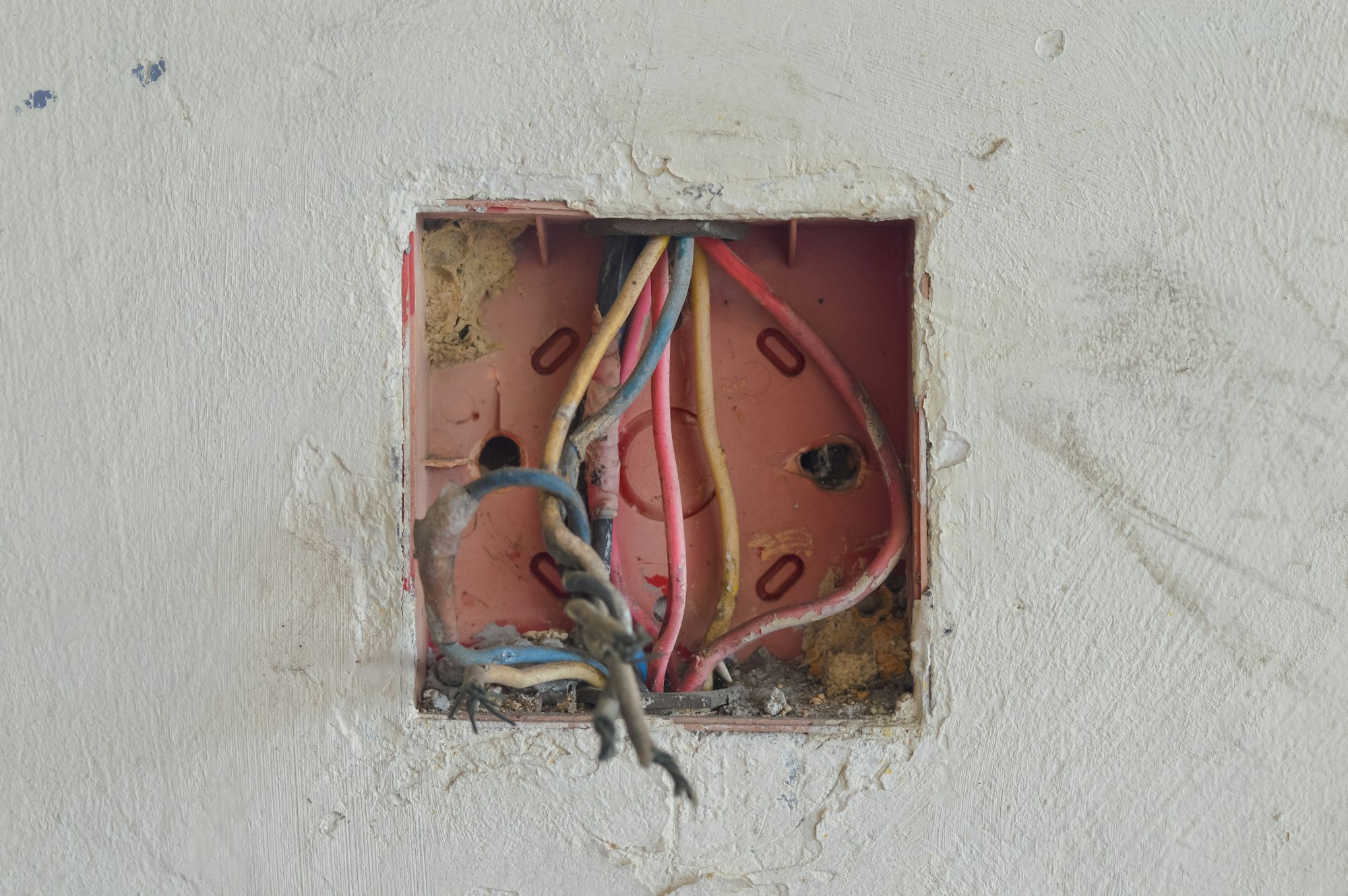 Firele, piulițele de sârmă și pânzele de păianjen aglomeran cutia de joncțiune, solicitând reorganizare și reparații electrice.