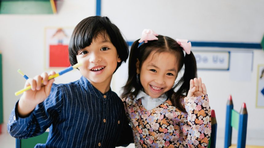 Copii asiatici fericiți care se distrează în sala de grădiniță.