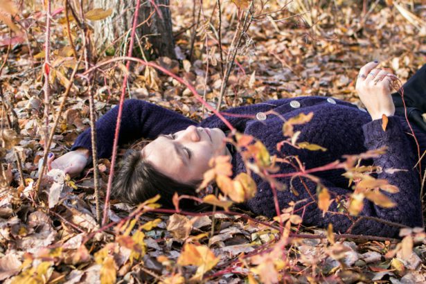 O femeie care se conectează pașnic cu natura într-o pădure senină de toamnă.