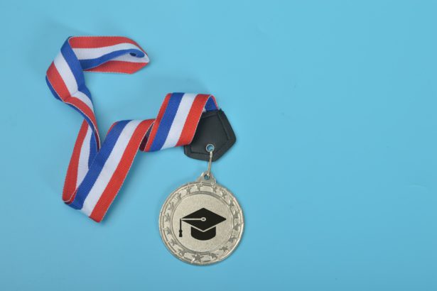Medalie de argint cu simbolul pălăriei de absolvire.