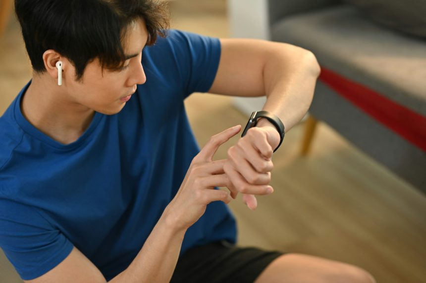 Tânăr om de fitness verifică ceasul inteligent pentru a monitoriza rezultatele antrenamentului.