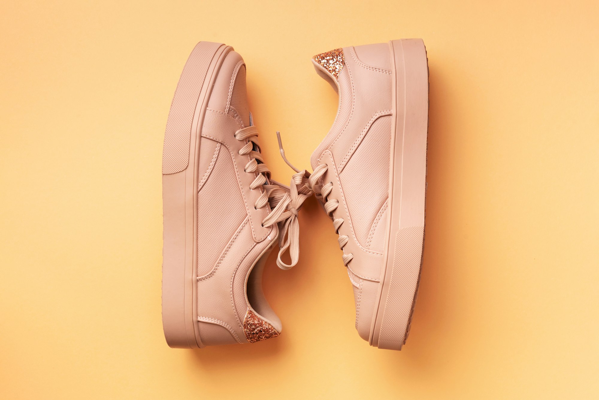 Pantofi roz de modă pentru femei pe fundal roz cu spațiu pentru copiere.