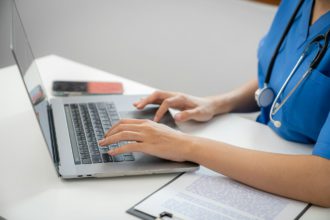 Medic profesionist care folosește un laptop Consultație Mesaje online cu aplicația de consultare online pentru asistența medicală a pacientului