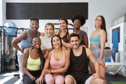 grup multicultural de oameni de fitness care se uită la camera și zâmbesc la sală