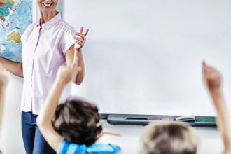 Profesor care predă copiii în sala de clasă la școală