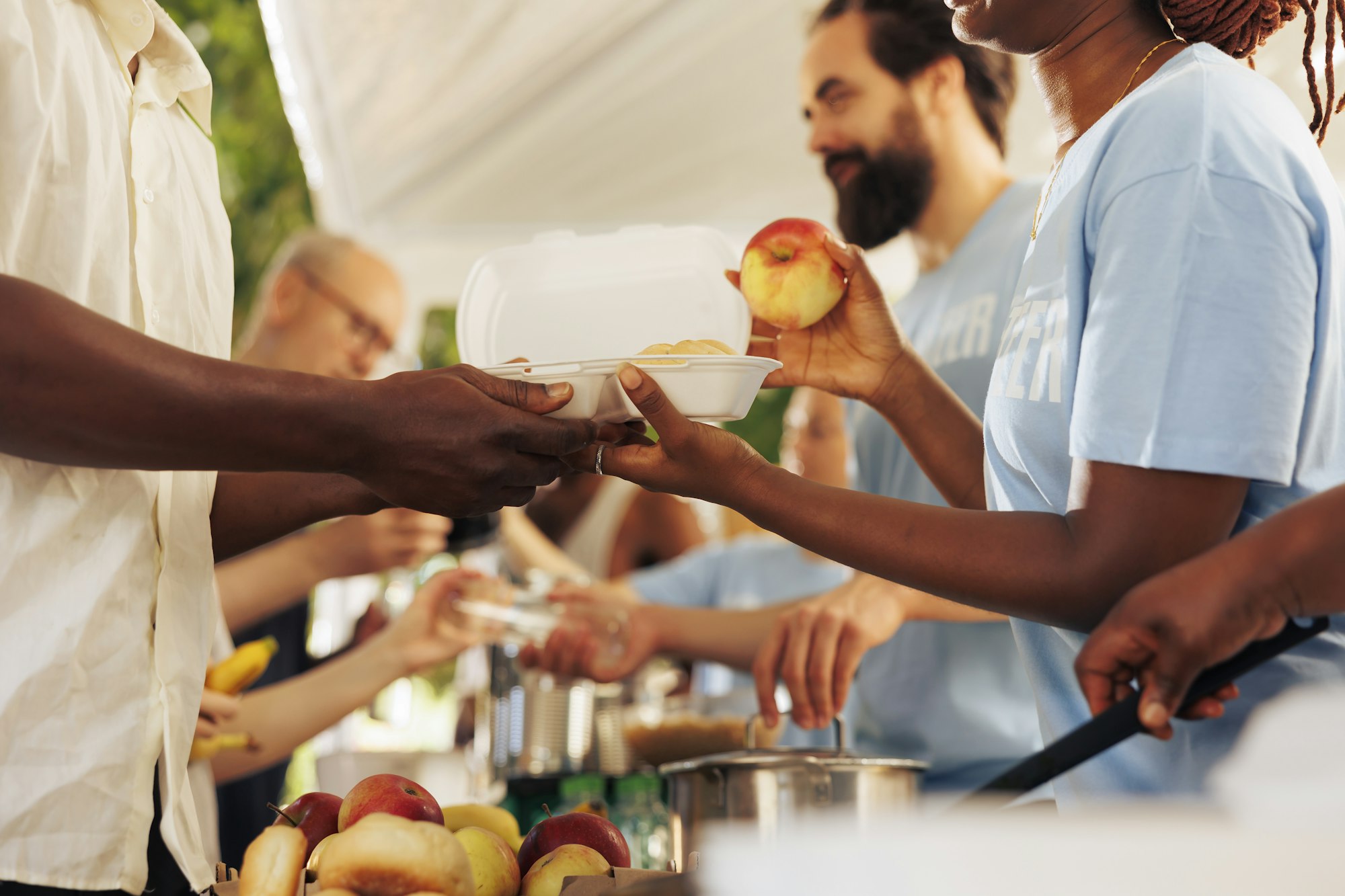 Donație generoasă de articole neperisabile care este înmânată persoanelor nevoiașe de către voluntari prietenoși, evidențiind impactul carității.