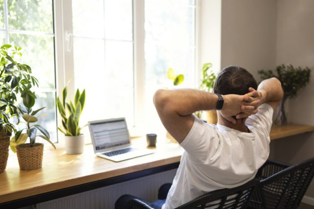 Tânăr antrenor de dezvoltare personală care răspunde clientului prin e-mail cu un laptop în timp ce face o pauză într-o cafenea.