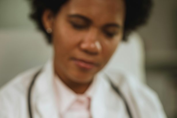 Fotografie cu o doctoriță africană care se simte stresată și ia medicamente în timp ce lucra în biroul ei în timpul pandemiei de COVID-19.