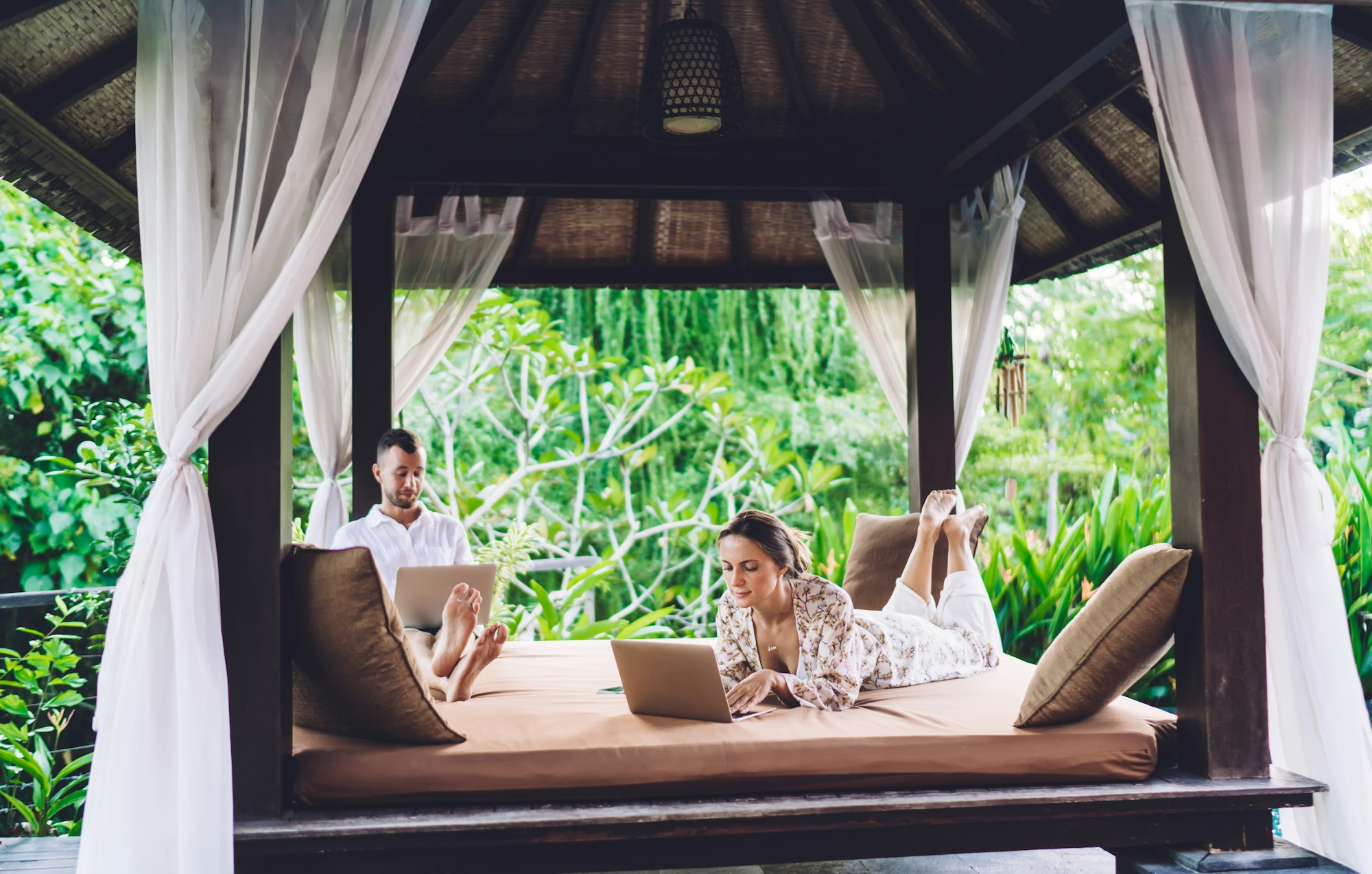 Bărbați și femei tinere care folosesc wireless 4g pentru chat și mesagerie prin tehnologia netbook-uri în timpul petrecerii timpului liber în weekend pe o terasă confortabilă