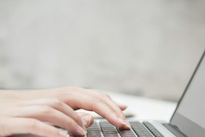 Prim-plan cu mâna unei femei de afaceri care tastează pe tastatura laptopului