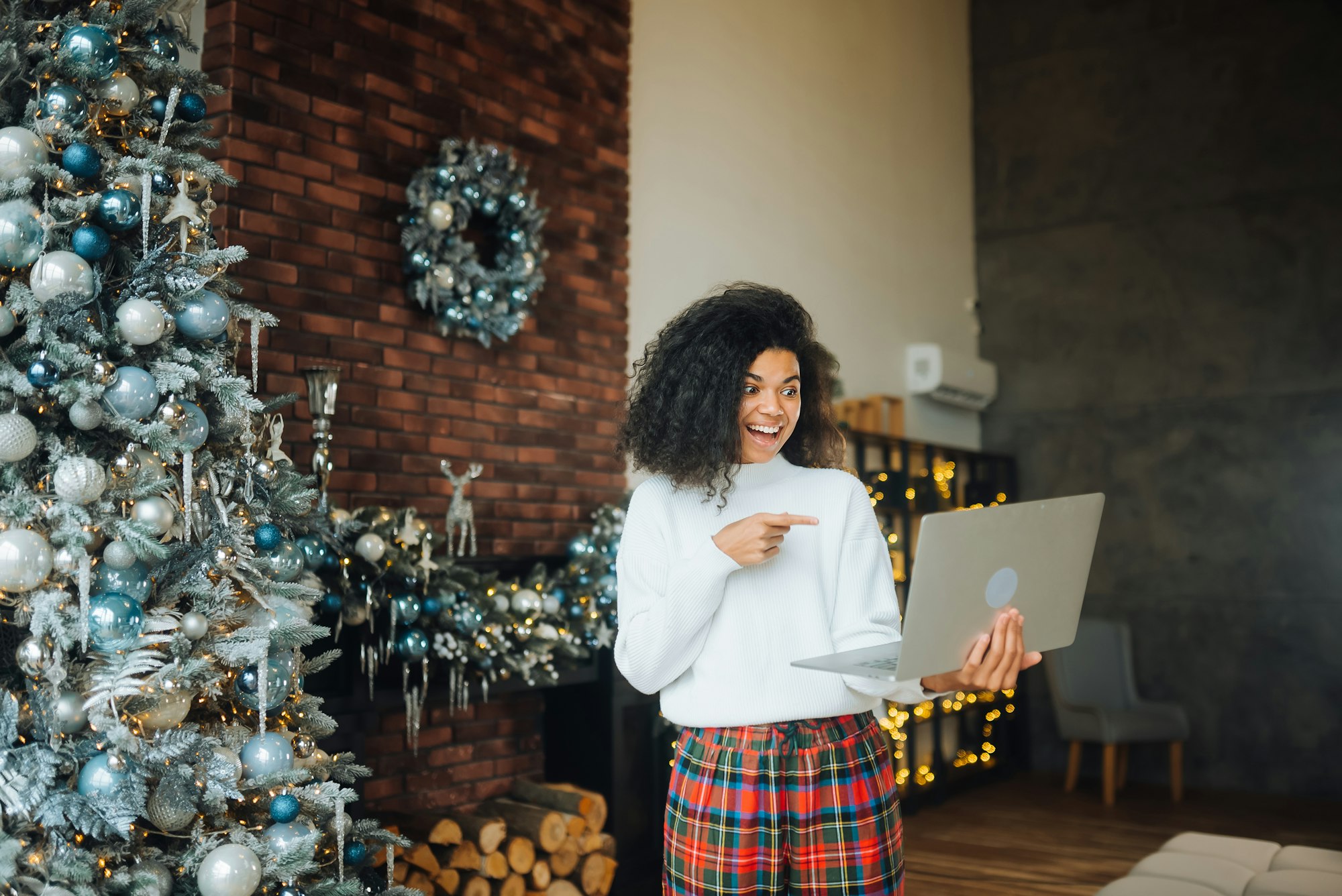 Drăguță, atrăgătoare, drăguță, bucuroasă, nebună, veselă, vesela, cu părul ondulat, care ține în mână laptopul, atingerea obiectivului