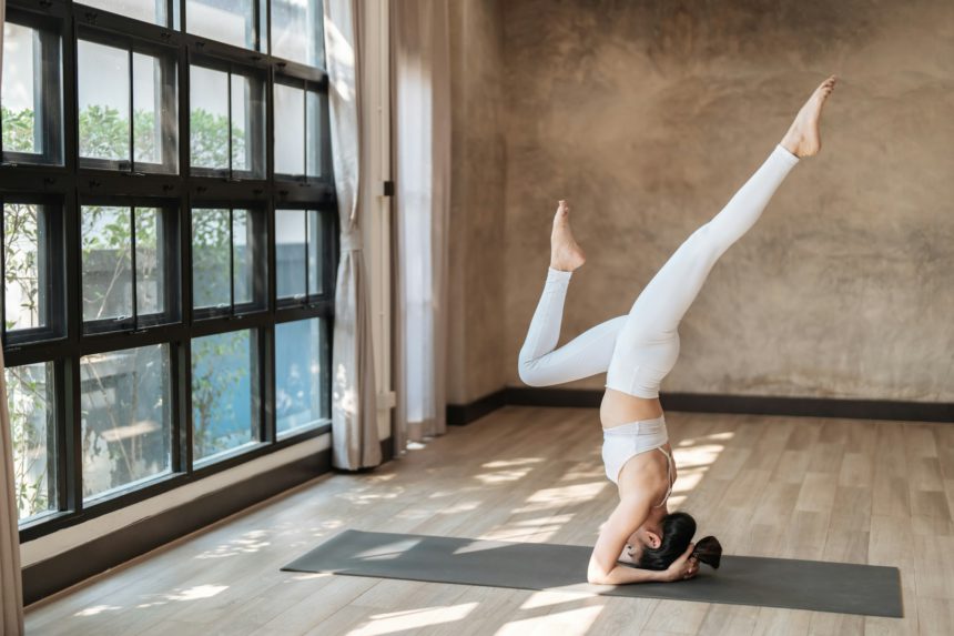 Femeie asiatică de fitness care face exerciții de întindere yoga pe mat yoga exerciții de fitness.