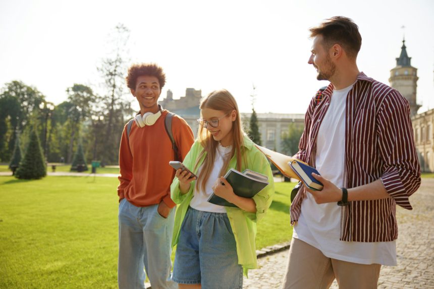 Studenți veseli care împărtășesc vești bune în timp ce discută rezultatele examenului.