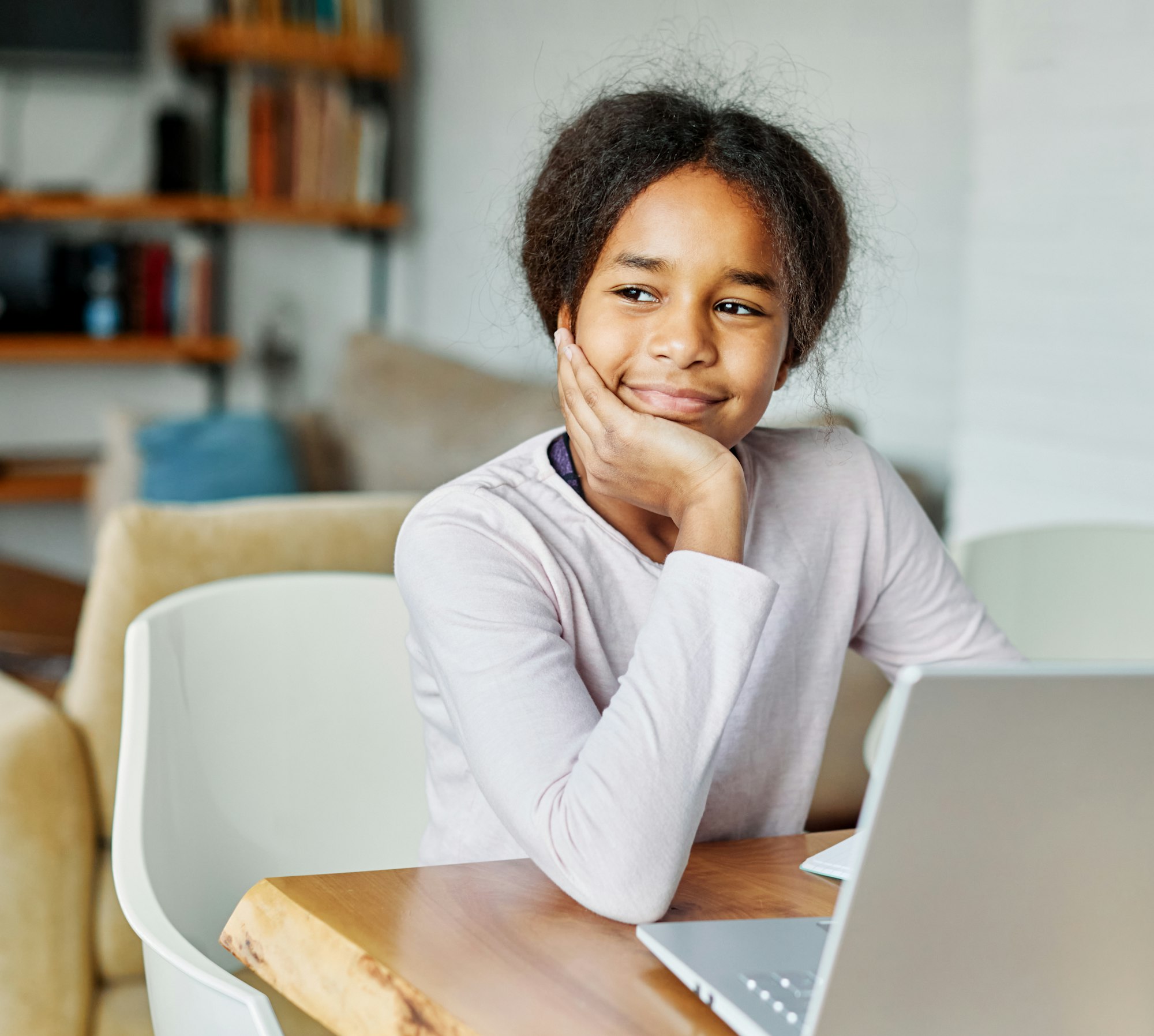 Portretul unei adolescente distrându-se folosind laptopul sau făcând temele cu laptopul acasă