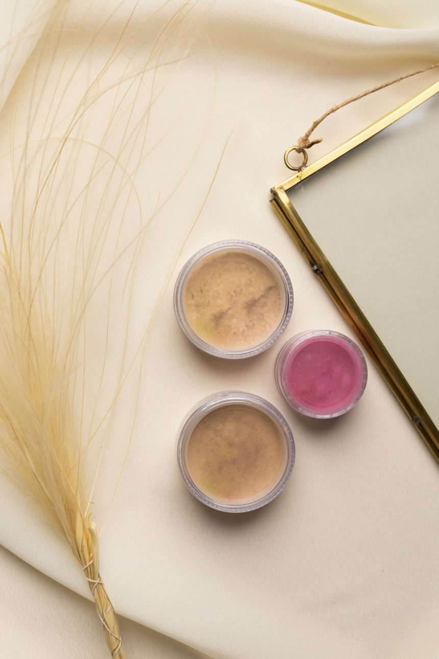 Cosmetice pudra faciala si fard de obraz pentru obraji pe fond natural cu flori uscate.