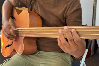 Un muzician profesionist de sex masculin nerecunoscut Gen x cântă la o chitară bas electric special fără fret