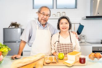 Cuplu bătrân asiatic senior trăind fericit în bucătărie acasă.