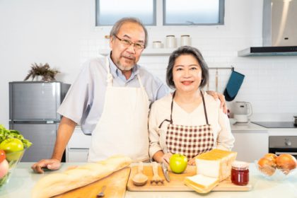 Cuplu bătrân asiatic senior trăind fericit în bucătărie acasă.