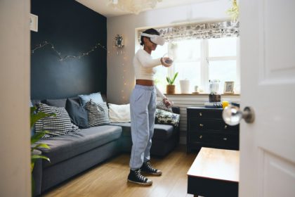 Adolescentă purtând cască de realitate virtuală acasă